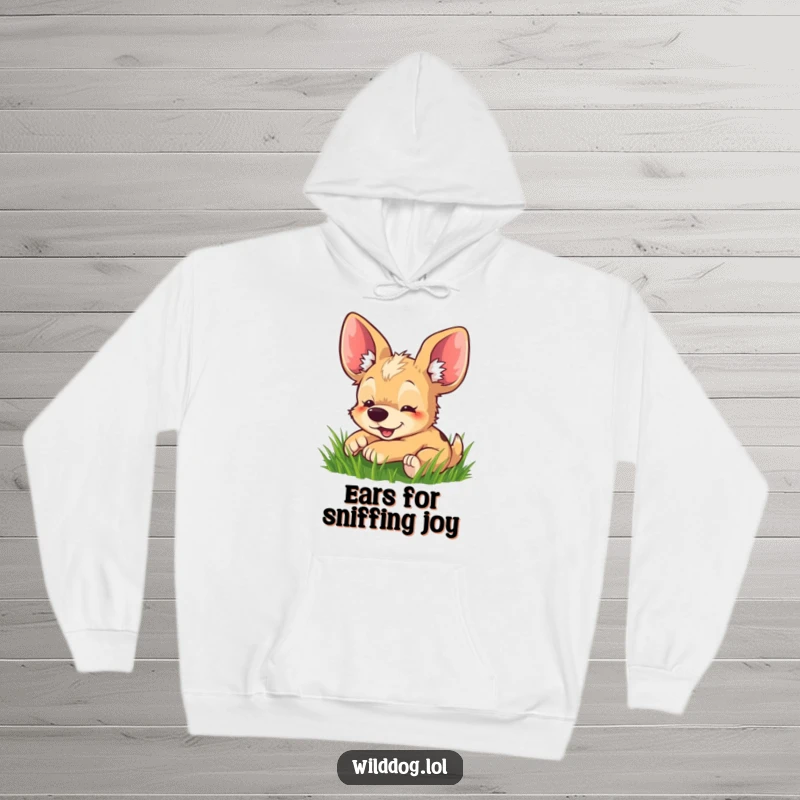 Funny hoodie featuring a delighted wild dog with exceptionally large ears gleefully rolling in soft green grass.
